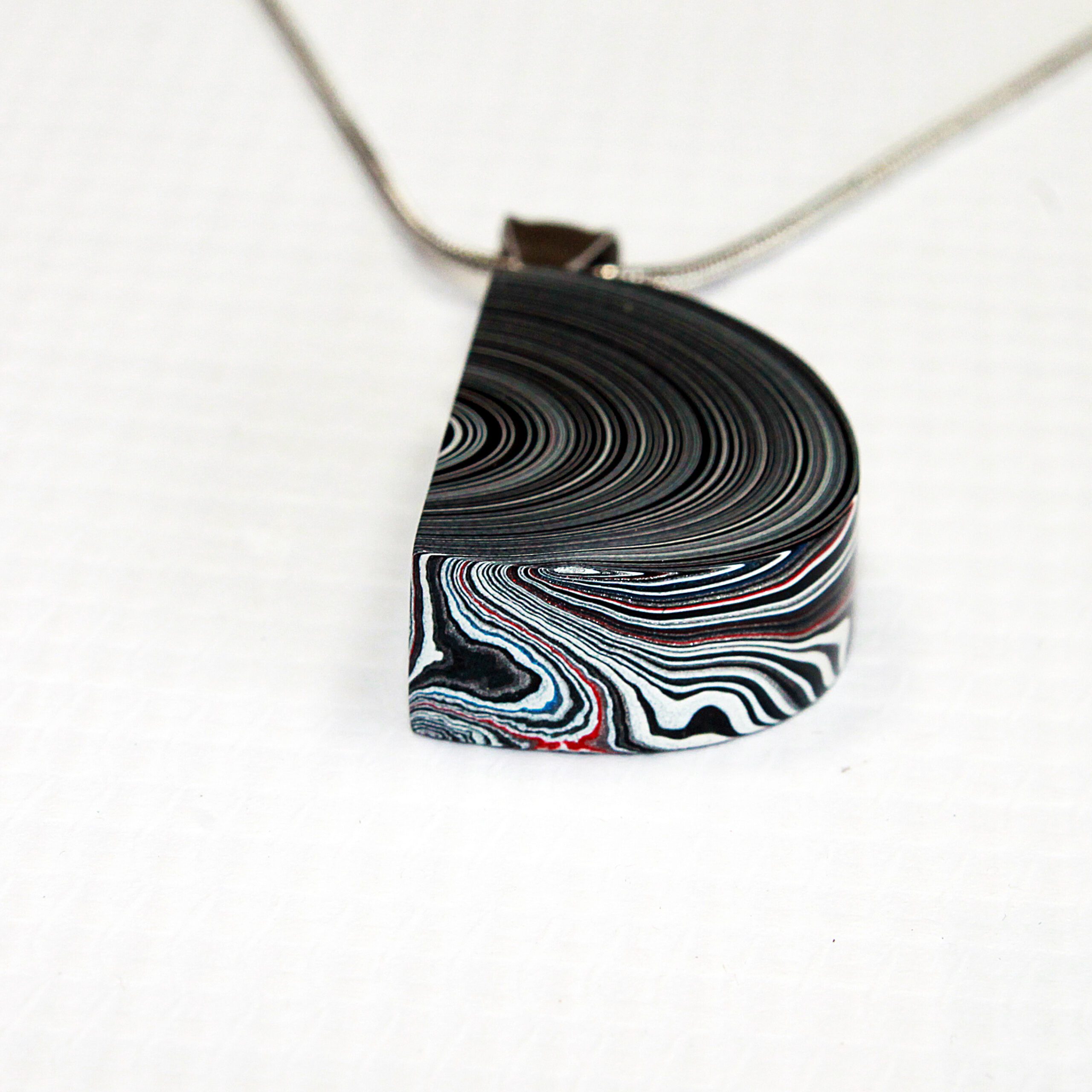 Layered pendant with swirling patterns.