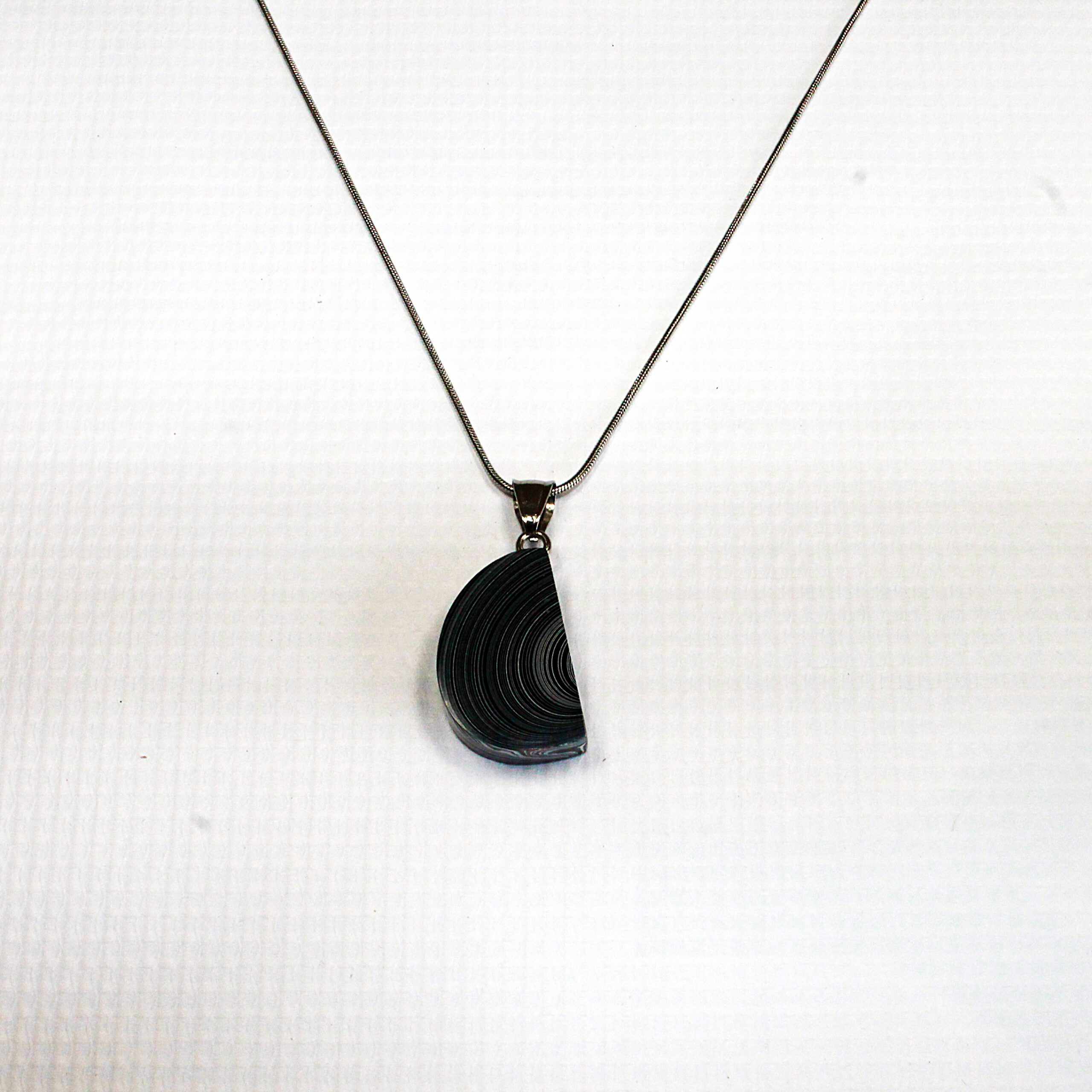 Half-circle pendant on silver chain necklace.