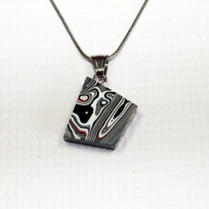Geometric pendant with colorful layered pattern.