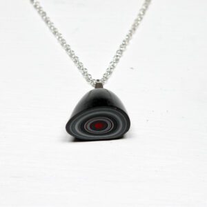 Pendant with concentric circles on chain.