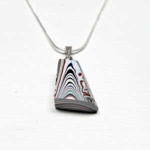 Colorful geometric pendant necklace on white background.