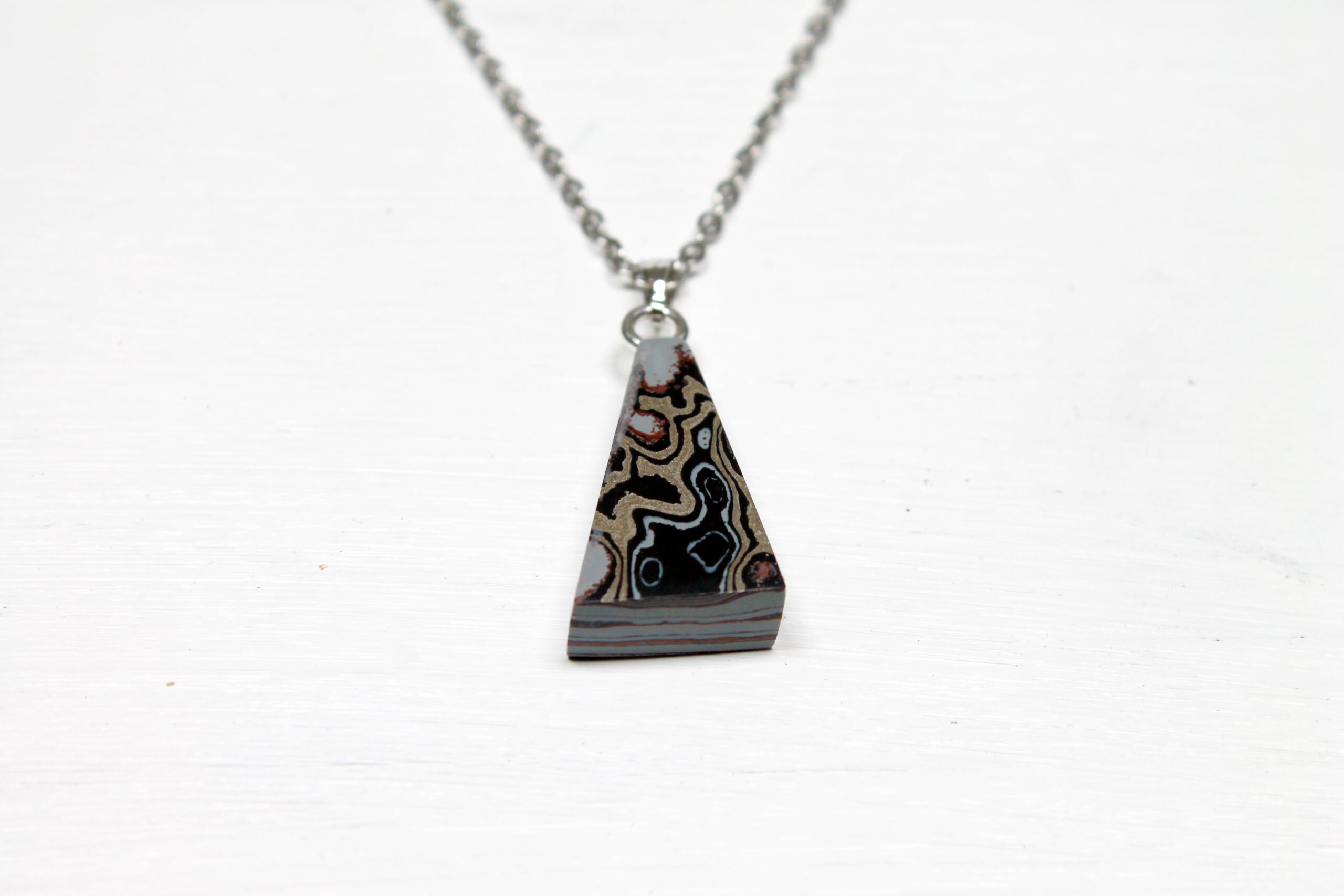Geometric pendant necklace with abstract pattern.