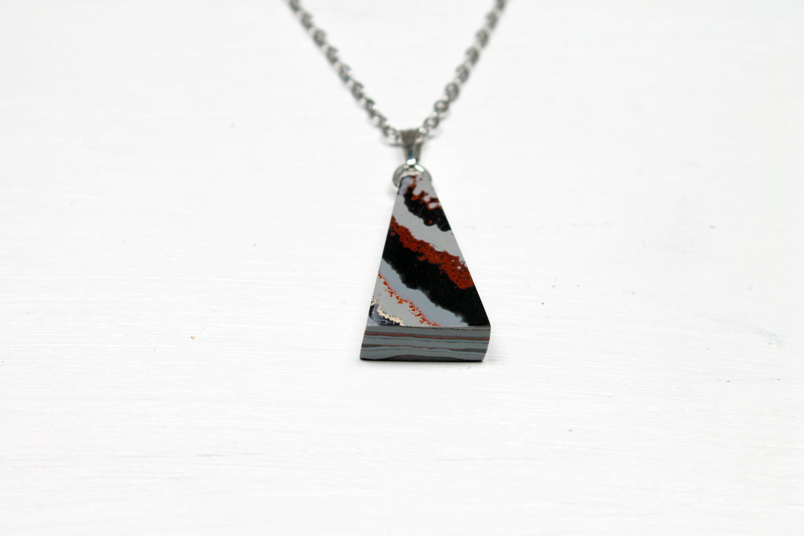 Triangular stone pendant on silver chain.