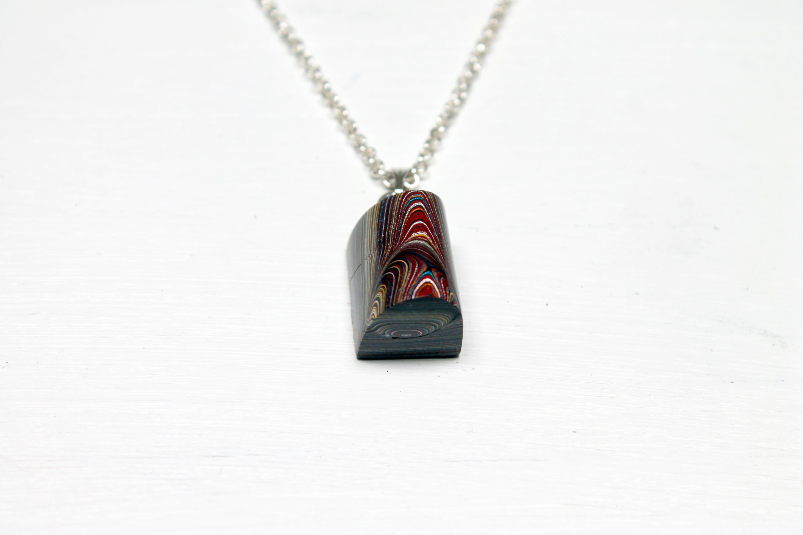 Colorful pendant with chain on white background.