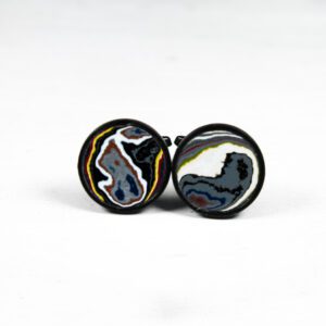 Colorful round cufflinks on white background.