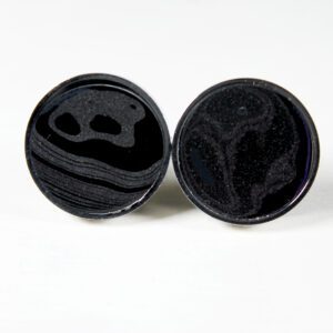 Black circular cufflinks with abstract design.