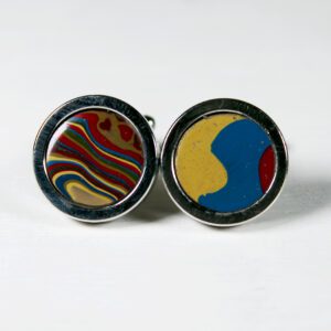 Colorful round cufflinks on white background.