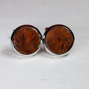 Wooden cufflinks on white surface.