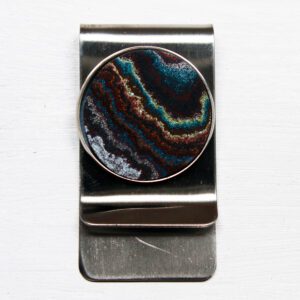 Metal money clip with colorful circular design.