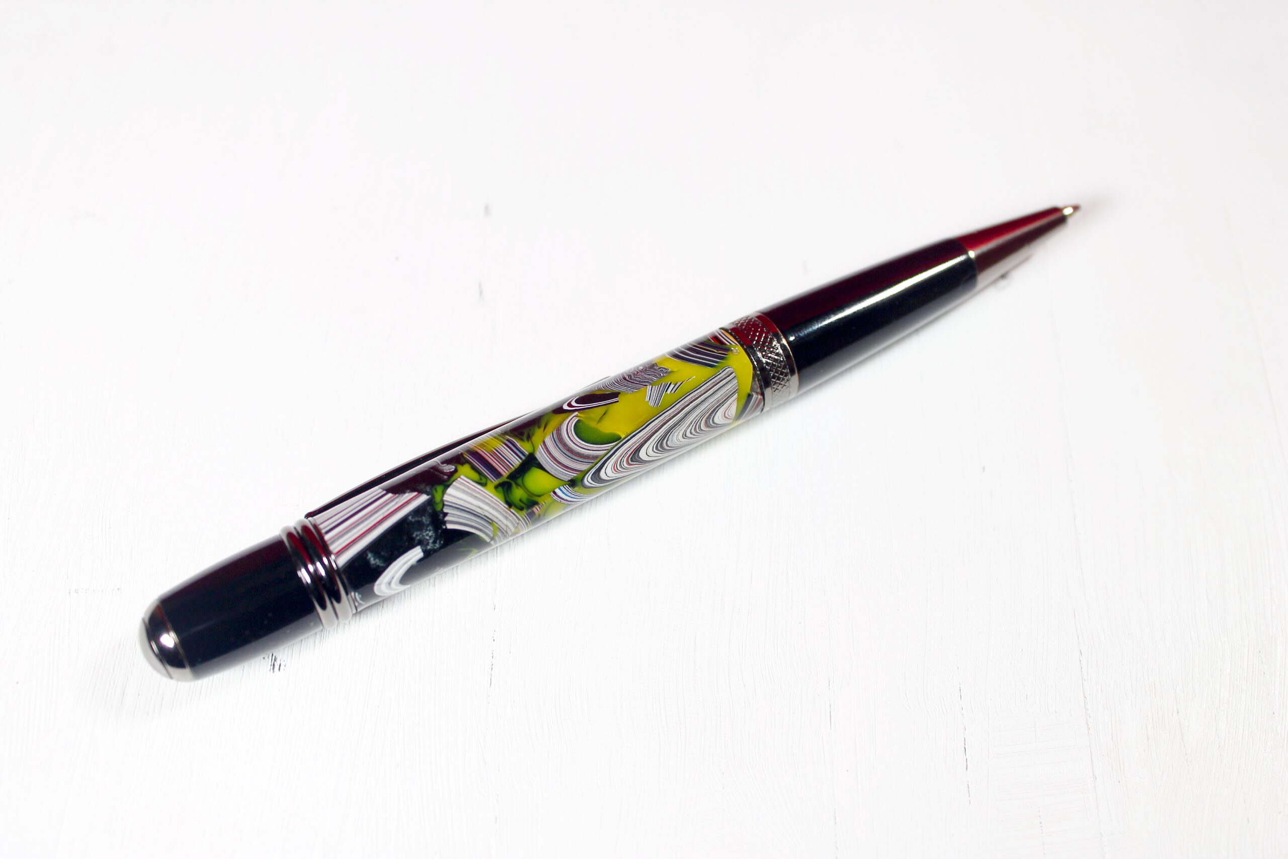 Colorful pen with intricate design on white background.
