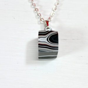 Striped stone pendant on a silver chain.