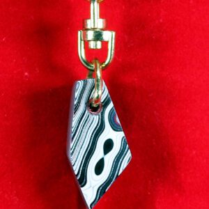 Gold keychain with abstract black-white pendant.