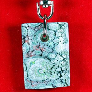 Colorful patterned pendant on red background.