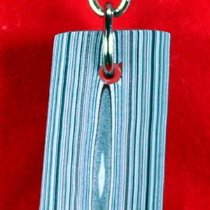 Striped keychain on a red background.