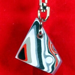 Geometric keychain on red background.