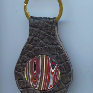 Leather keychain with colorful circular design.