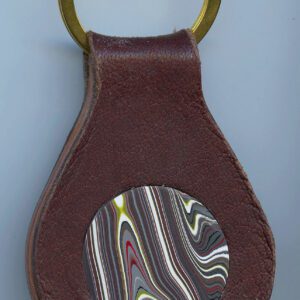 Leather keychain with colorful circular design.