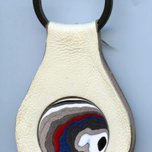 White leather keychain with abstract design.