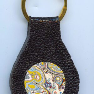 Textured keychain with colorful circular design.