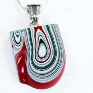 Pendant with red, black, and white swirls.