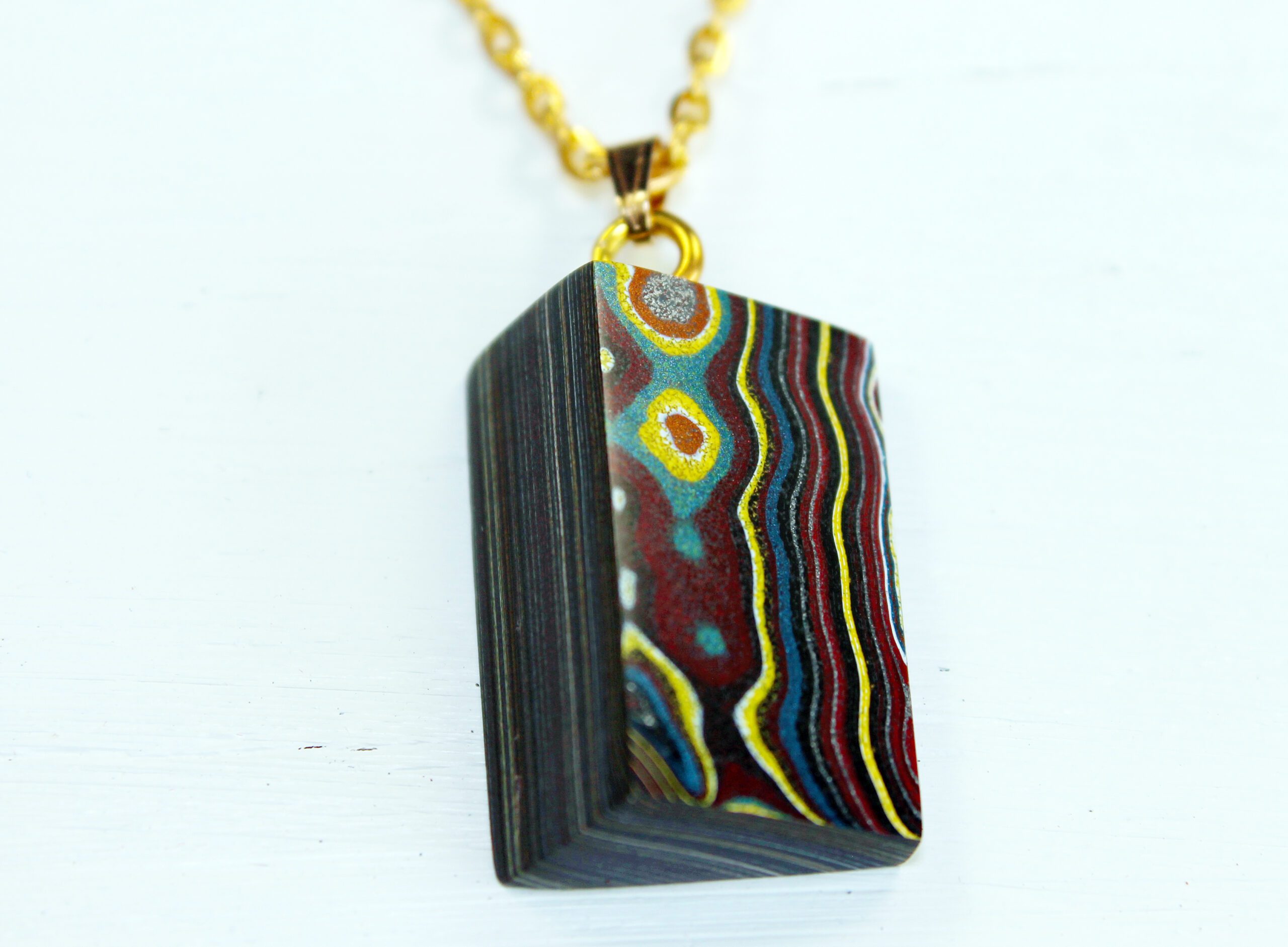 Colorful pendant with geometric, wavy patterns.