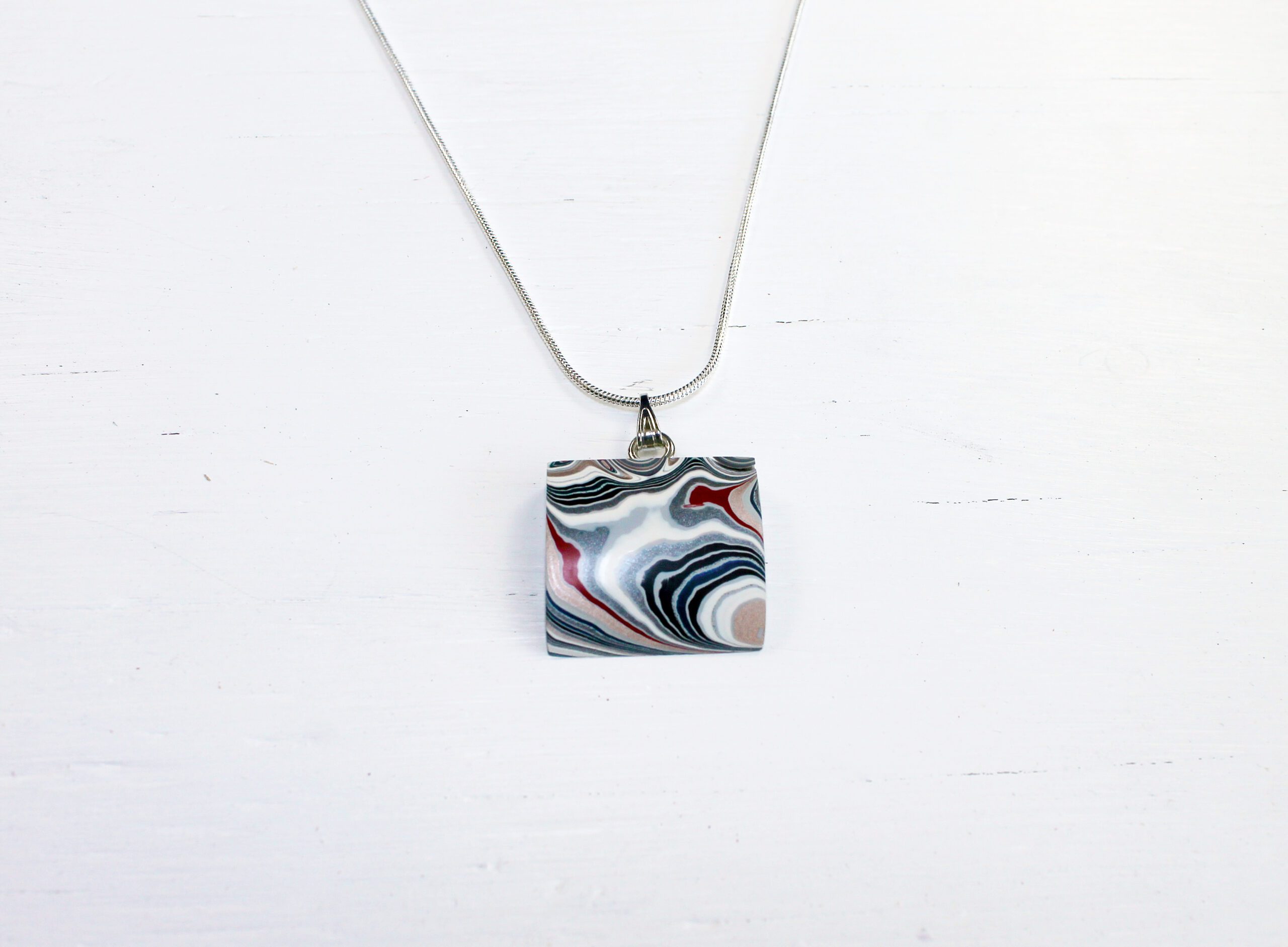 Necklace with abstract patterned pendant design.