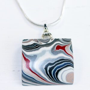 Pendant with abstract swirl pattern design.