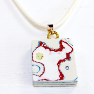 Rectangular pendant with abstract design on necklace.