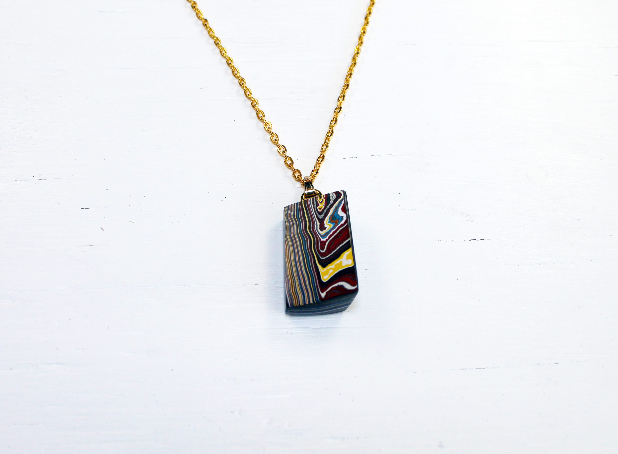 Colorful pendant on gold chain necklace.