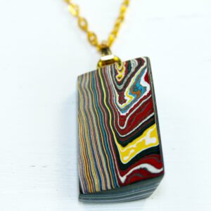 Colorful layered pendant on gold chain.