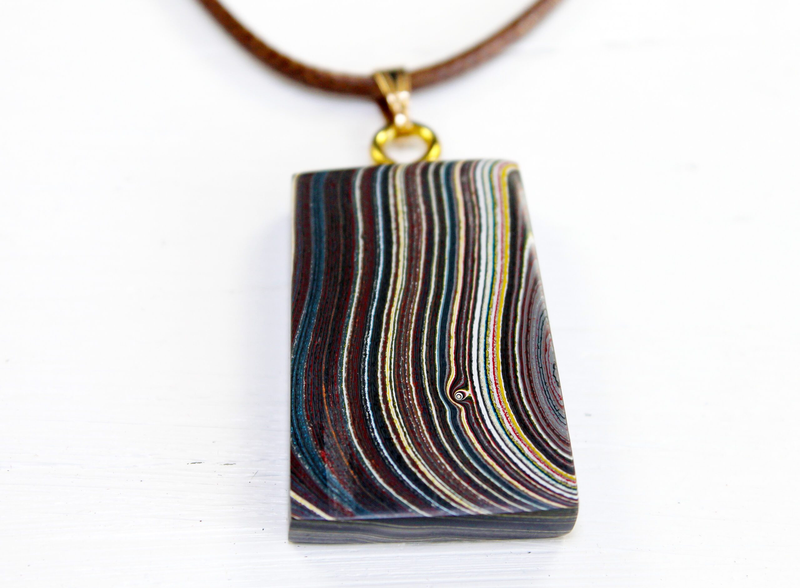 Colorful pendant with swirling striped pattern.