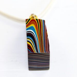 Multicolored pendant with layered abstract design.
