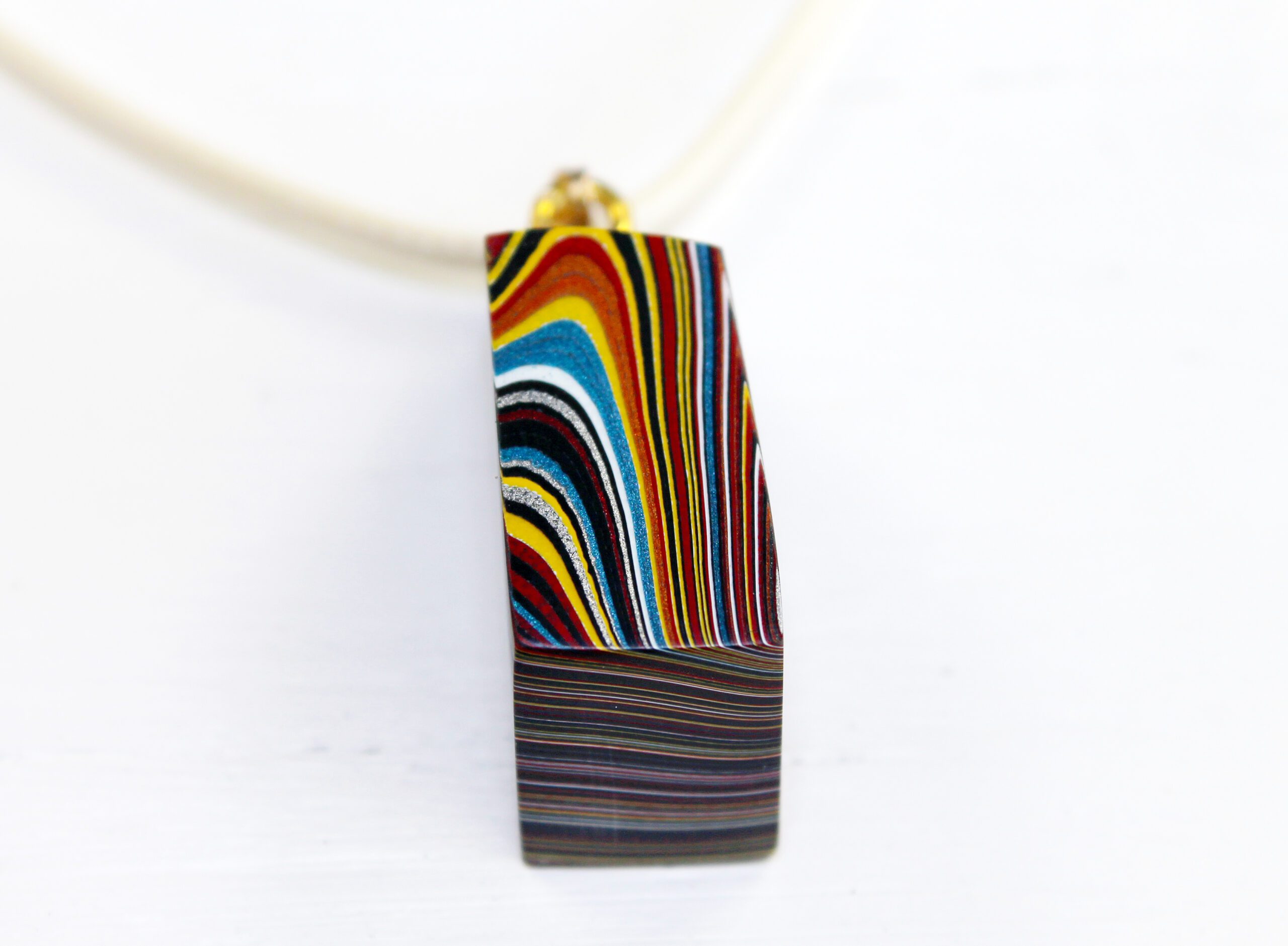 Multicolored pendant with layered abstract design.