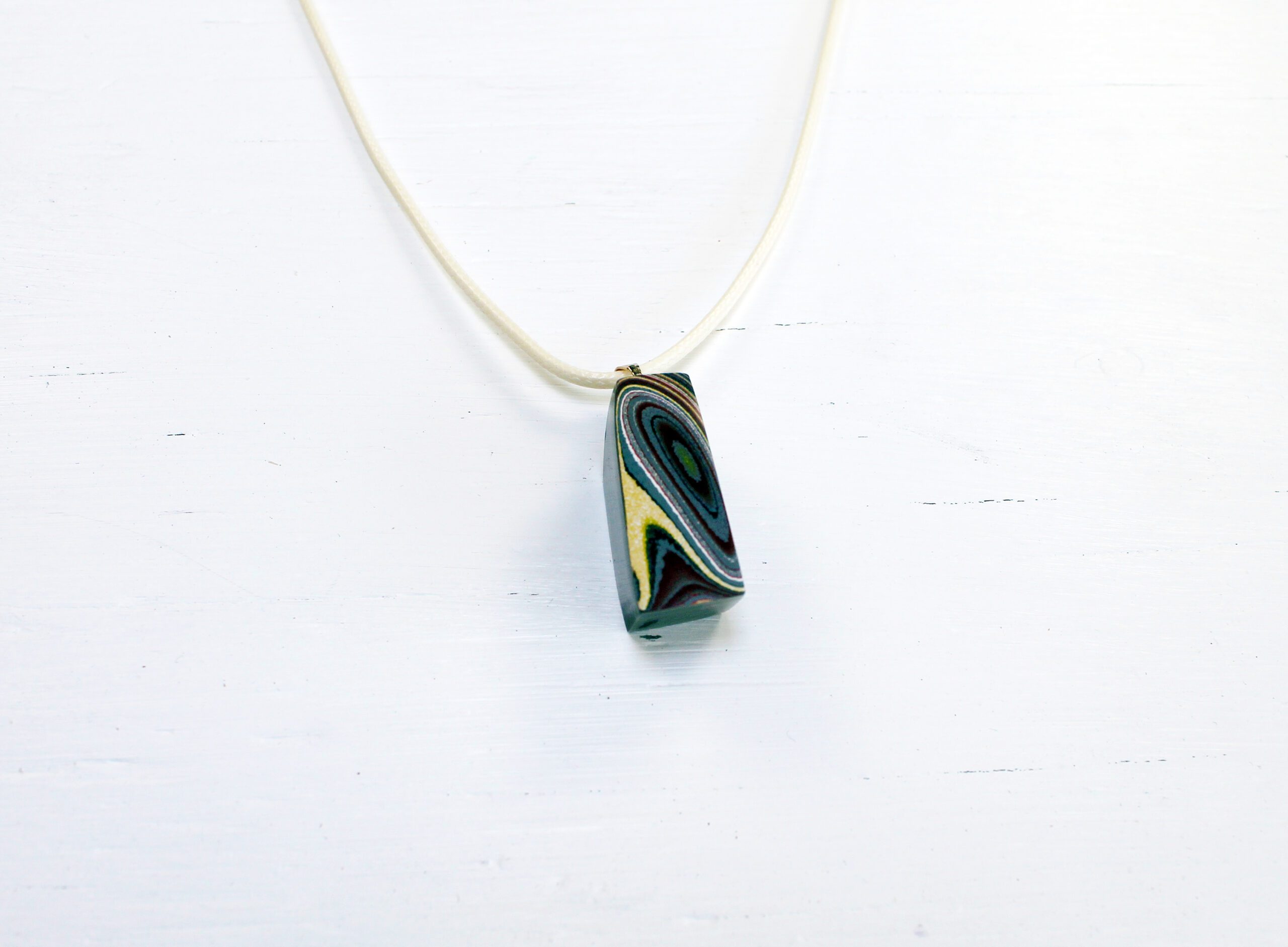 Pendant necklace with abstract design on display.