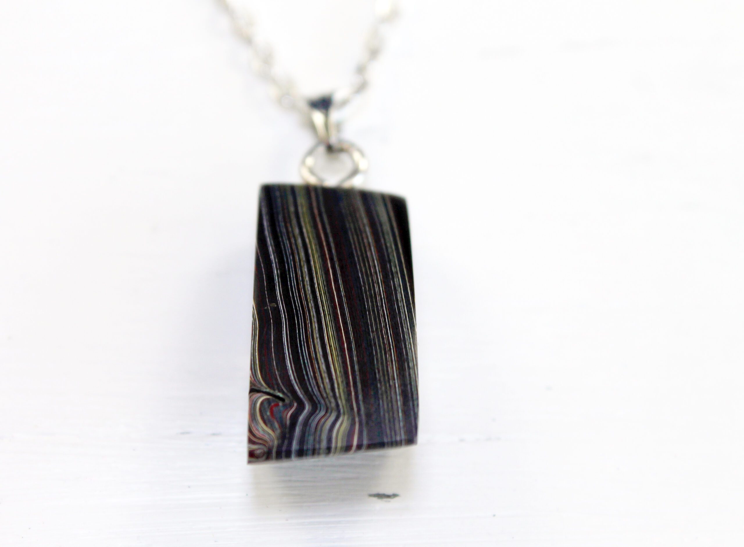 Striped pendant necklace on a silver chain.