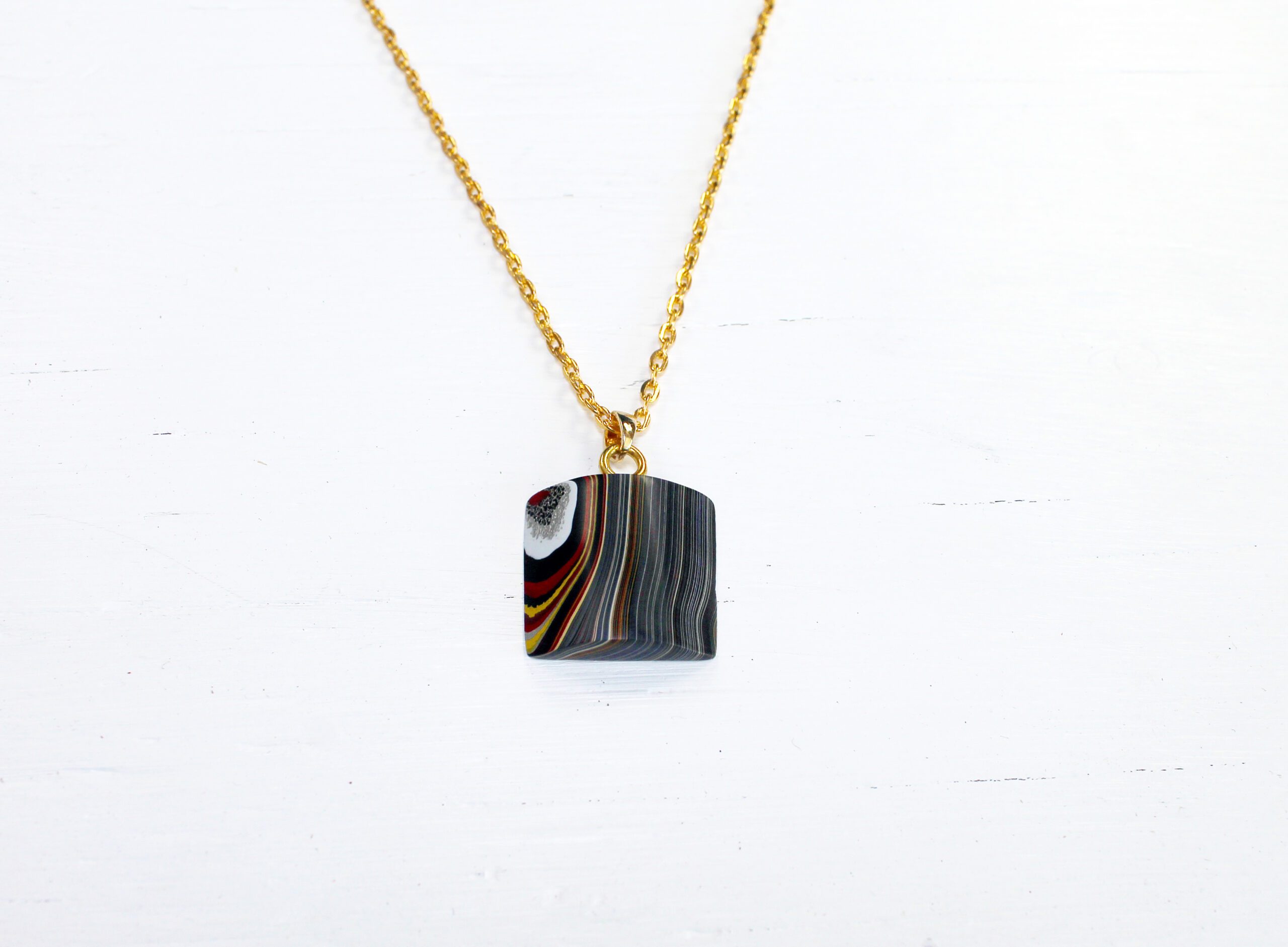 Gold chain with colorful stone pendant.