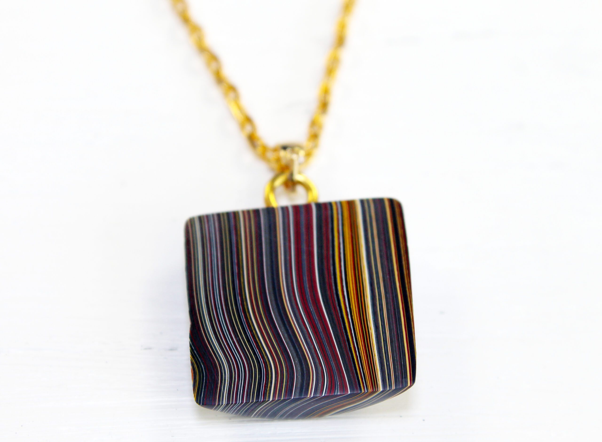 Colorful striped pendant with gold chain.