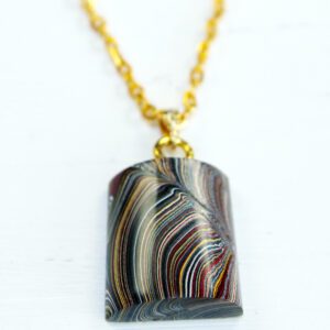 Colorful swirl pendant on gold chain necklace.