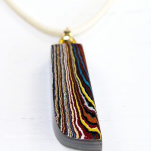 Colorful layered pendant on white background.