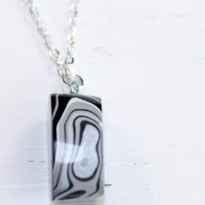 Pendant with abstract black and white design.