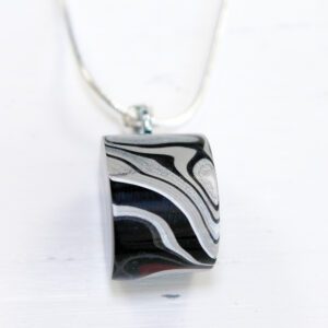 Black and white swirl pendant on necklace.
