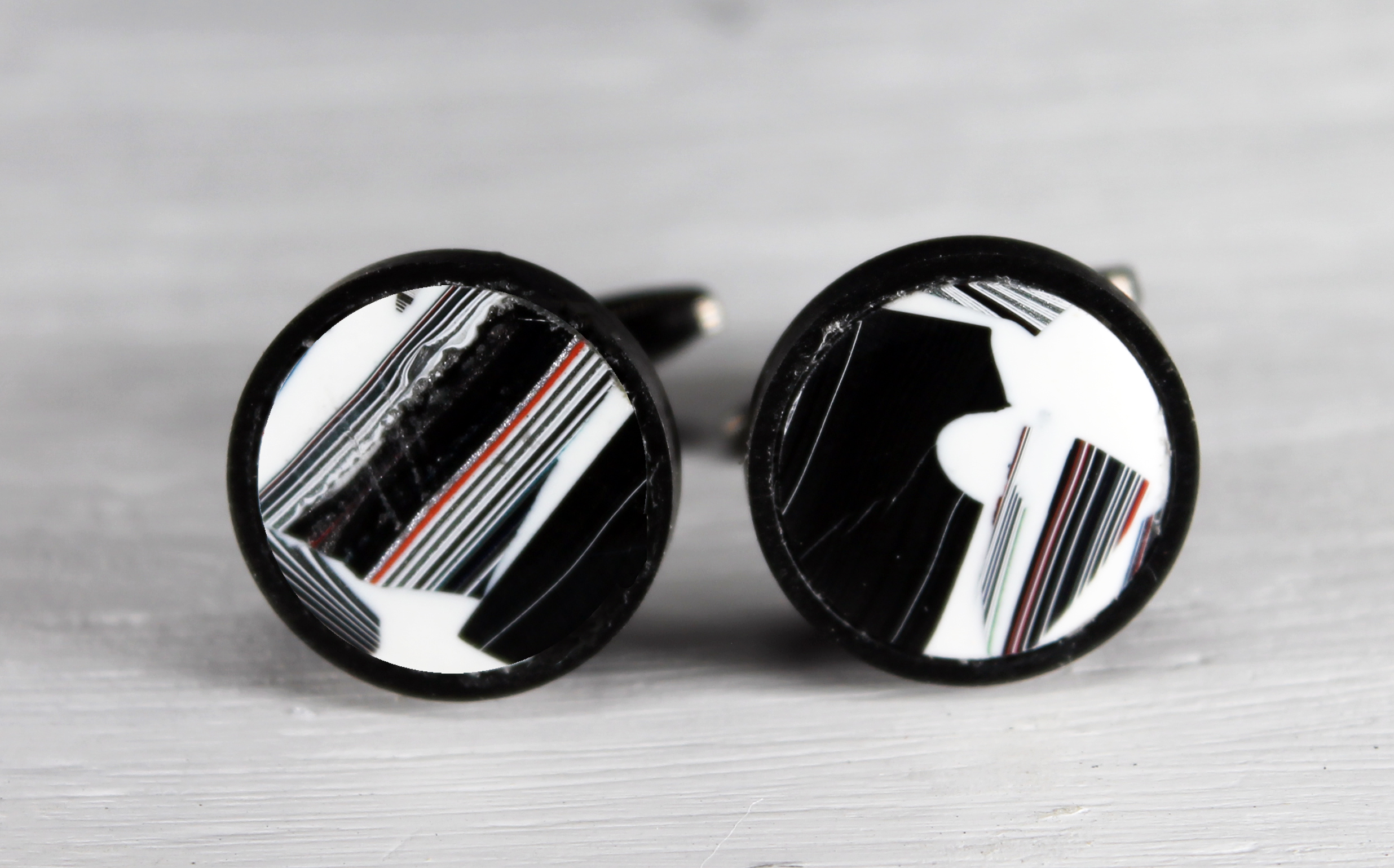 Black and white round cufflinks with stripes.