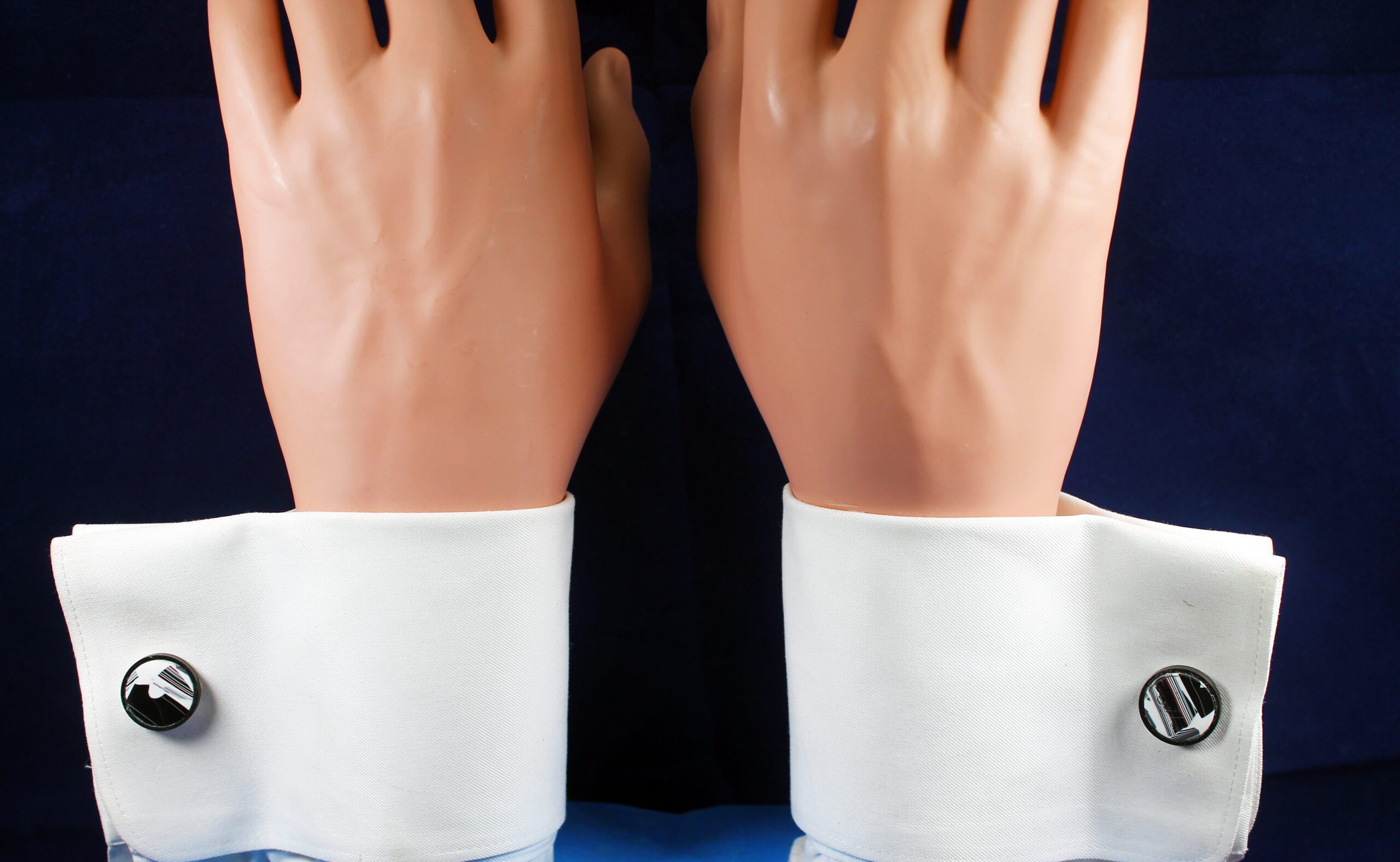 Mannequin hands with white cuffs and cufflinks.
