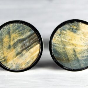 Round, abstract-patterned stud earrings on display.