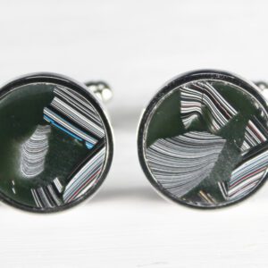 Round cufflinks with abstract striped design.