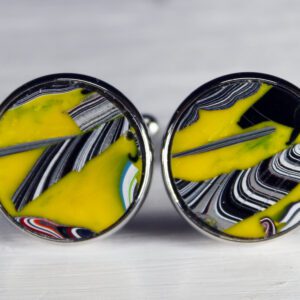 Yellow and black marbled cufflinks on display.