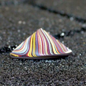 Colorful striped cone on dark textured surface