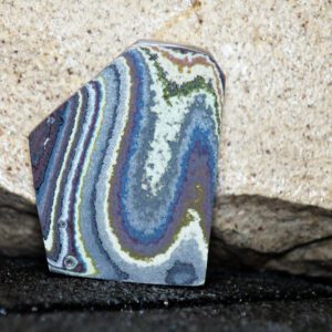 Colorful banded agate stone against rock