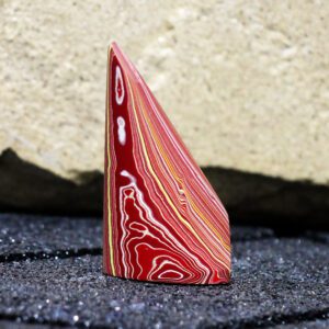 Polished red layered fordite stone upright
