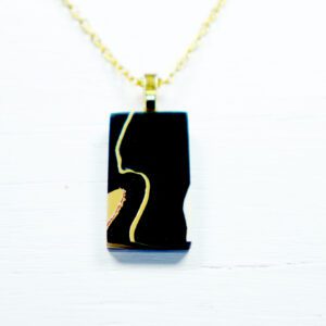Black rectangular necklace pendant with gold profile